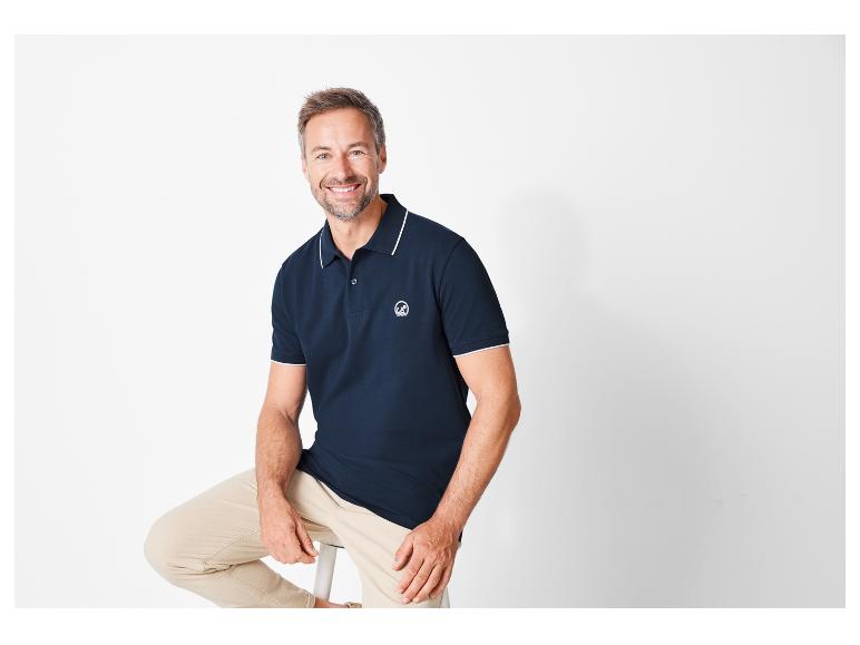 Polo homme marine à col contrastant et pantalon beige.