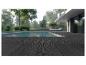 Terrasse composite foncée au bord d'une piscine avec transat et maison moderne en arrière-plan.