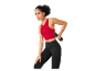 Femme faisant du sport avec des leggings et un haut de sport, haltères à la main.