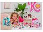 Une fille joue avec des poupées Kindi Kids, des accessoires et des maisons de poupées.