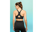 Une femme portant un soutien-gorge de sport noir et un legging.
