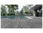 Terrasse composite grise au bord d'une piscine avec une maison moderne en arrière-plan.