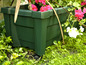 Jardinière verte sur roulettes pour fleurs.
