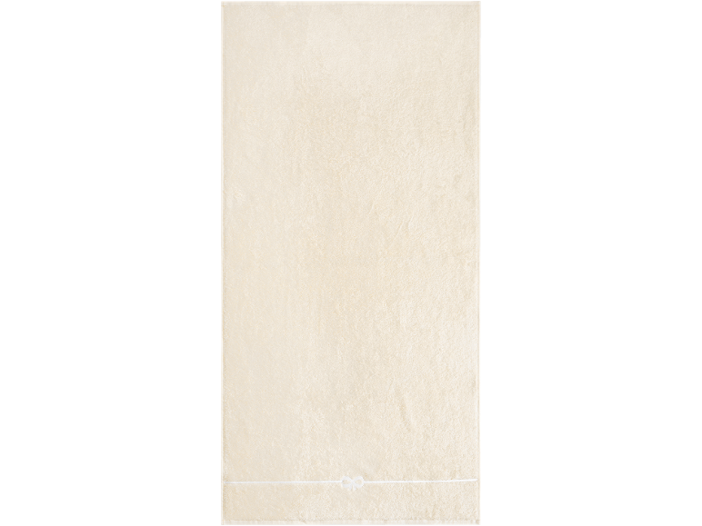 Serviette beige clair avec un nœud décoratif blanc.