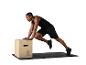 Homme faisant des exercices sur une boîte pliométrique et un tapis de sol.