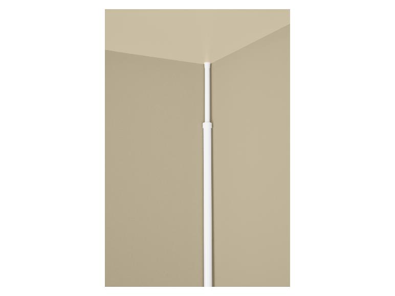 Tringle de douche télescopique blanche installée dans un coin de mur beige.