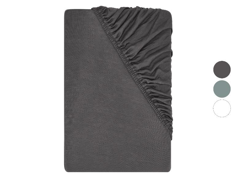 Drap-housse gris foncé avec élastique et échantillons de couleur.