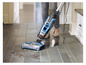 Une personne utilise un aspirateur Bissell CrossWave pour nettoyer un sol en carrelage.