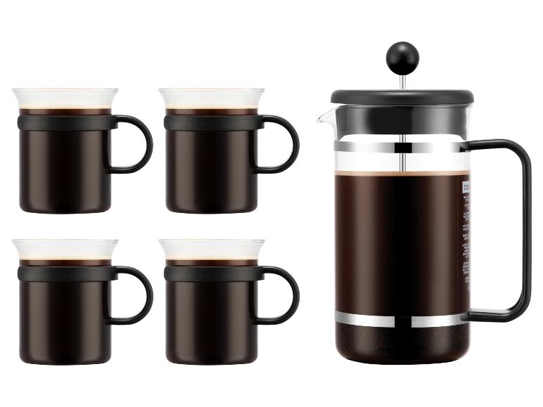 Une cafetière à piston et quatre tasses à café assorties remplies de café.