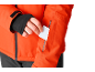 Homme met une carte blanche dans la poche d'une veste orange.