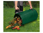 Une personne vide un sac de jardin vert avec des feuilles