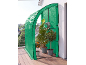 Serre de balcon verte avec plantes en pot, dont un kumquat et un palmier, sur un balcon en bois.
