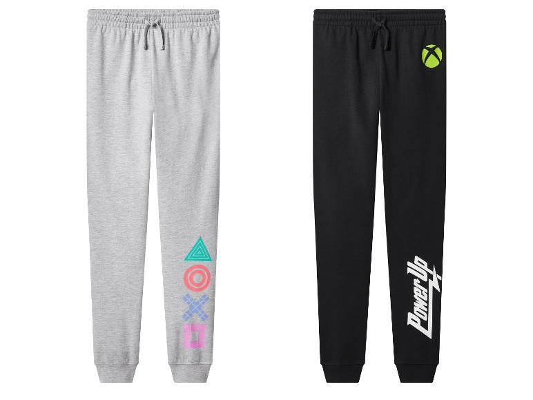 Deux pantalons de survêtement pour enfants : gris avec logo PlayStation et noir avec logo Xbox et texte 'Power Up'.