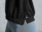 Un sweat-shirt noir à boutons et un pantalon de jogging bleu clair.