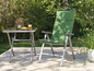 Une chaise pliante verte et une table assortie pour l'extérieur.