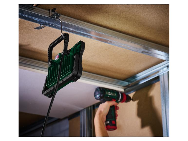 Lampe de travail LED suspendue et perceuse sans fil utilisées sur un chantier.