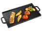 Saumon grillé, poulet et légumes sur une plaque de cuisson en fonte.