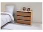 Une table de chevet en bois avec trois tiroirs dans une chambre à coucher.