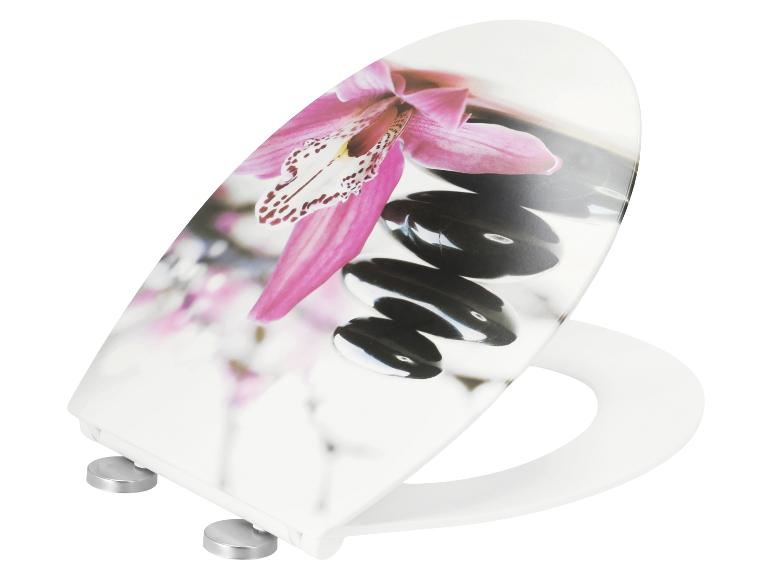 Abattant de toilettes blanc avec un motif d'orchidée rose et de pierres noires.