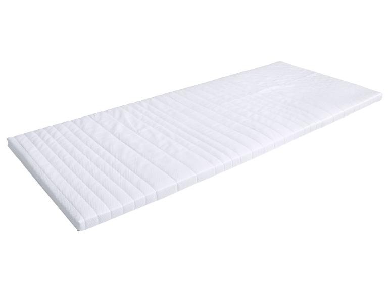 Protège-matelas ou surmatelas blanc avec coutures horizontales.