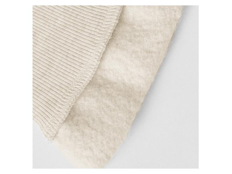 Détail d'un tissu côtelé beige et d'une doublure douce.