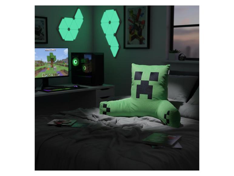 Chambre de jeu avec coussin personnage vert sur le lit, configuration d'ordinateur et lumières murales géométriques.