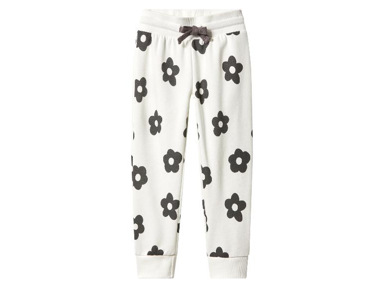 Pantalon de survêtement blanc pour enfant avec imprimé floral noir et cordon marron.