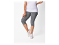 Femme portant un t-shirt blanc et des leggings gris.