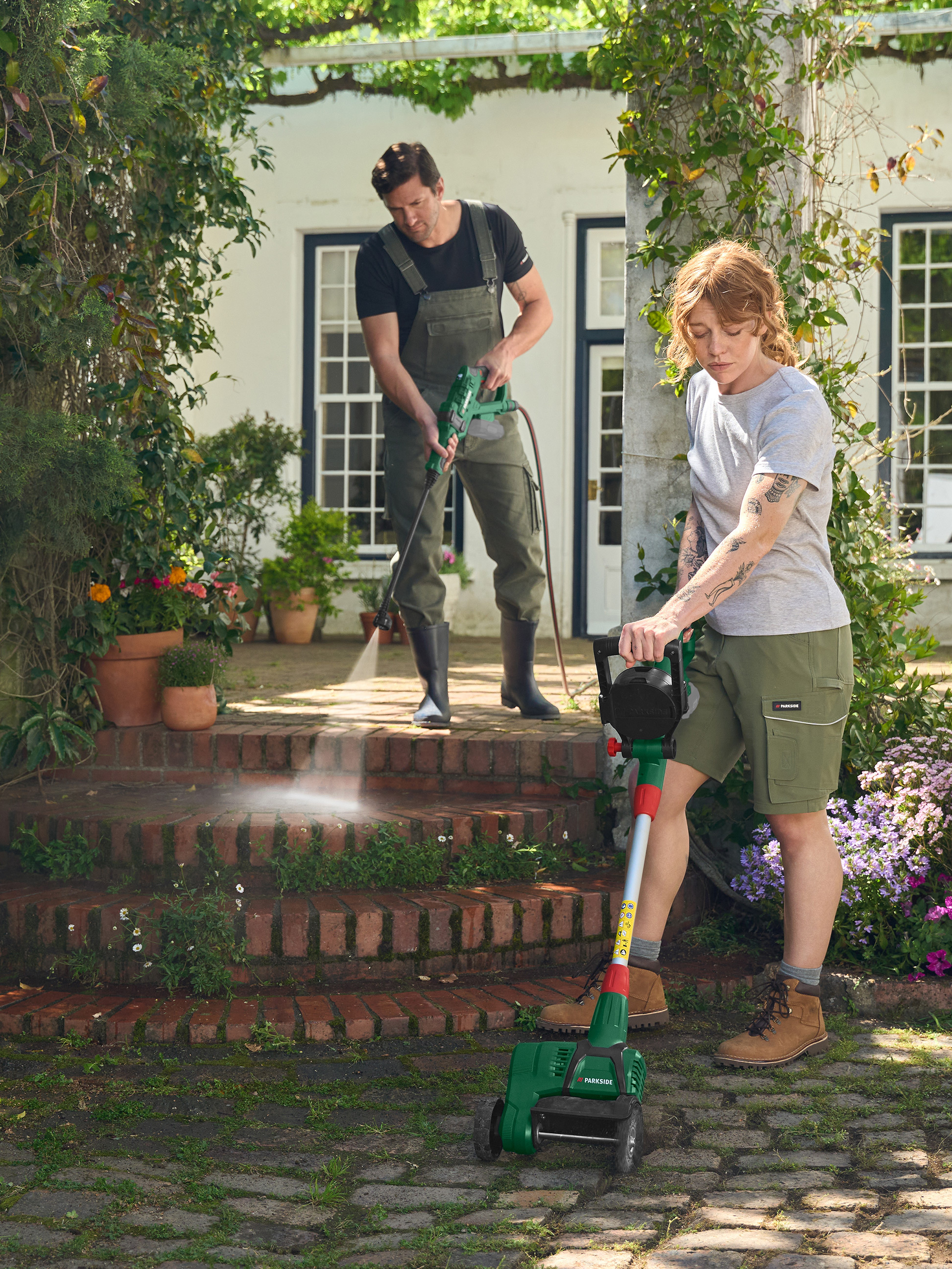 Homme utilisant un nettoyeur haute pression, femme une tondeuse Parkside dans le jardin.