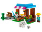 Un set LEGO Minecraft avec une maison, un fermier, un Creeper et un loup.