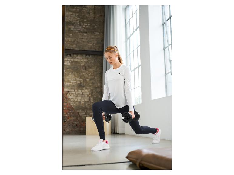 Femme en haut blanc à manches longues et leggings noirs faisant des fentes avec haltères.