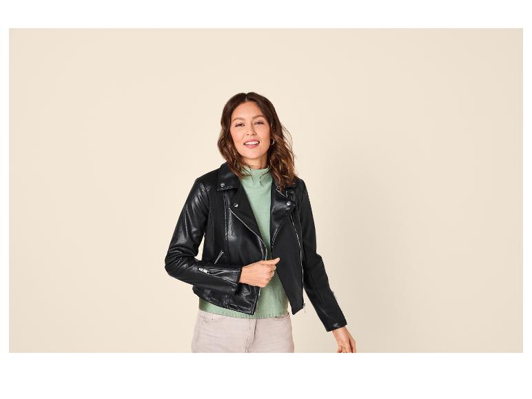 Femme souriante portant une veste en cuir noire et un pull vert menthe.