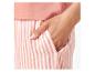 Gros plan sur un pantalon de pyjama rayé rose.