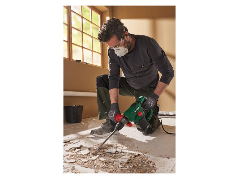 Un homme utilisant un marteau perforateur Parkside pour démolir des carreaux.
