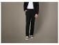 Pantalon de survêtement noir et baskets blanches.