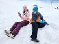 Deux enfants en vêtements d'hiver jouent dans la neige.