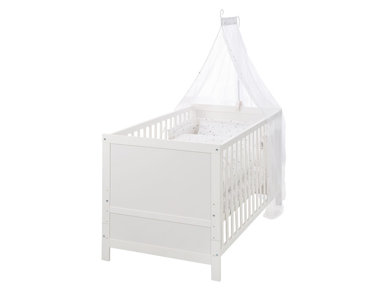 Lit bébé blanc avec ciel de lit et draps à étoiles