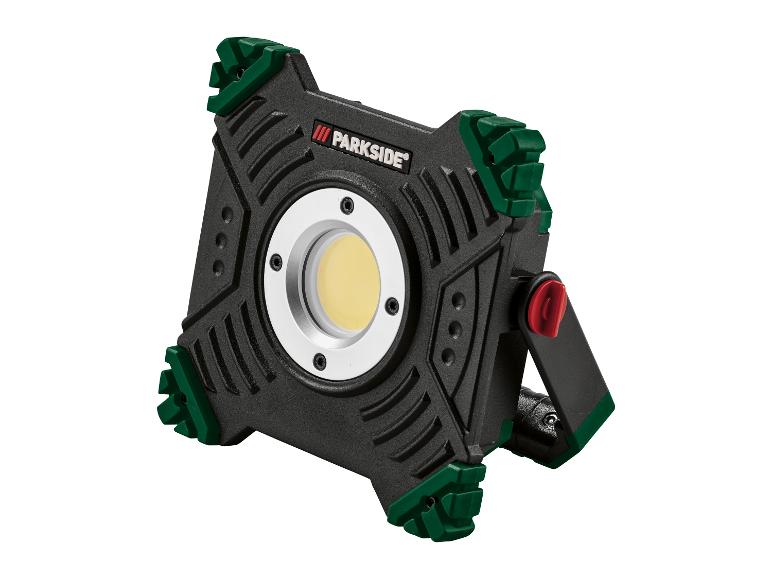 Projecteur de travail LED noir et vert avec lumière jaune et bouton rouge.