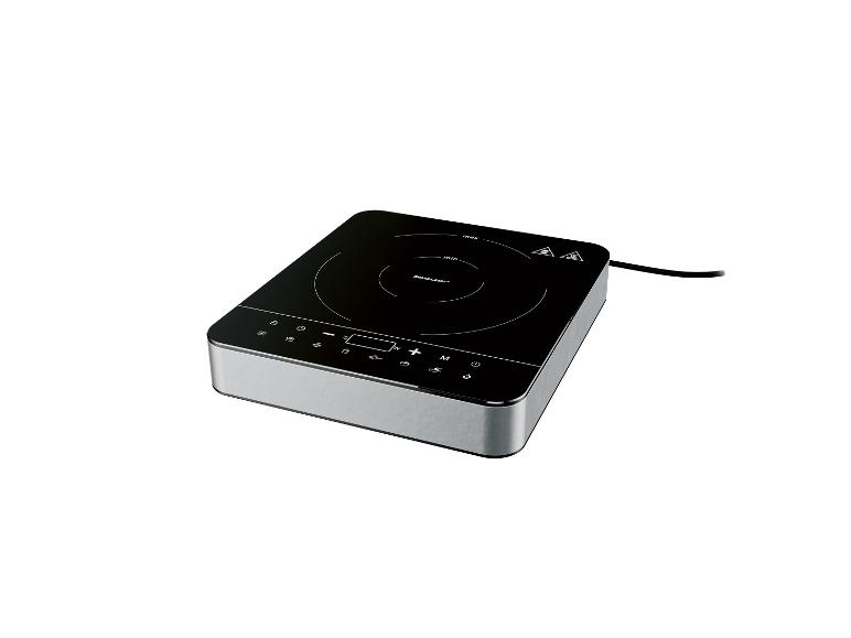 Une plaque de cuisson à induction SilverCrest argentée avec une surface noire.