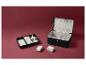 Un coffret à bijoux noir avec plusieurs compartiments pour les bagues, les boucles d'oreilles et autres bijoux.