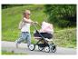 Un enfant pousse une poussette Maxi-Cosi rose.