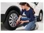 Une femme utilise un compresseur Ultimate Speed pour gonfler un pneu de voiture.