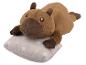 Peluche capybara allongée sur un oreiller à pois.
