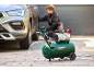 Compresseur d'air et personne changeant un pneu de voiture.