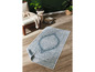 Un tapis bleu avec un motif blanc détaillé.
