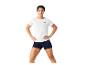 Femme en t-shirt blanc et short bleu foncé, mains sur les hanches.