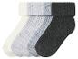Trois paires de chaussettes en blanc, gris et noir.