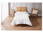 Une couette blanche sur un lit en bois dans une chambre à coucher.