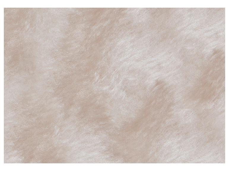 Gros plan sur le revêtement en peluche beige et doux du mur d'escalade pour chat.