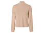Un pull beige à col roulé à manches longues.